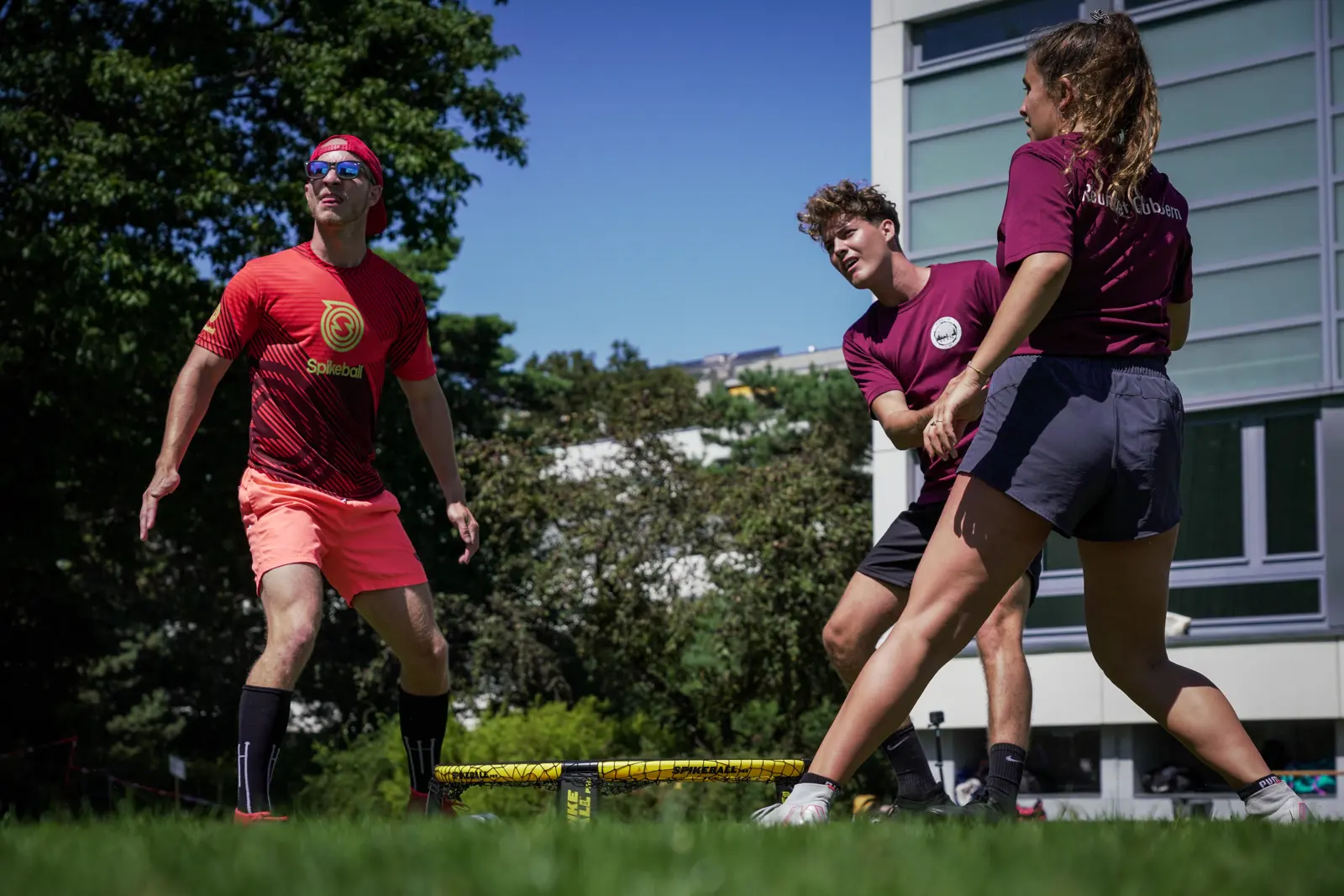 Roundnet match in Bern, July 2020: Jakub in a red Spikeball jersey against Ramon Felix and Nora in maroon shirts