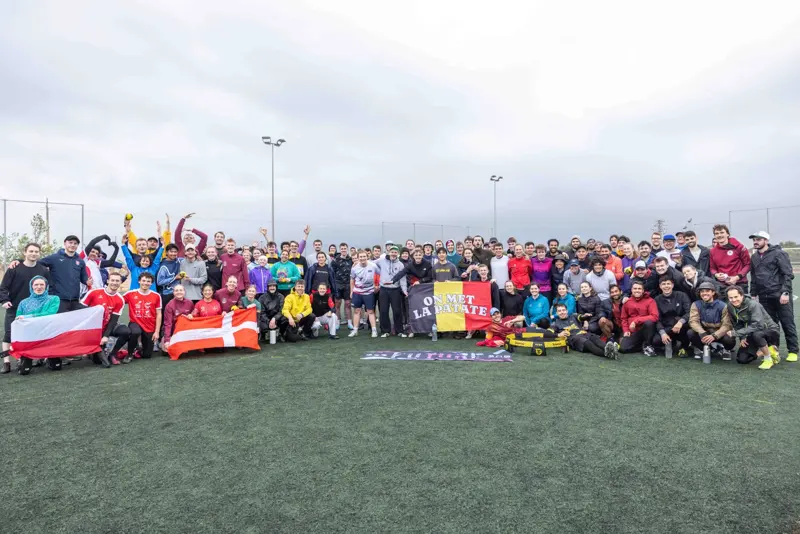 About a hundred players in one group photo on the pitch, holding flags from several nations